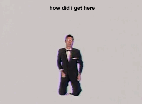 A gif of David Byrne saying "How did I Get Here?" with the same text above him, from the Talking Heads music video for their song "Once in a Lifetime"